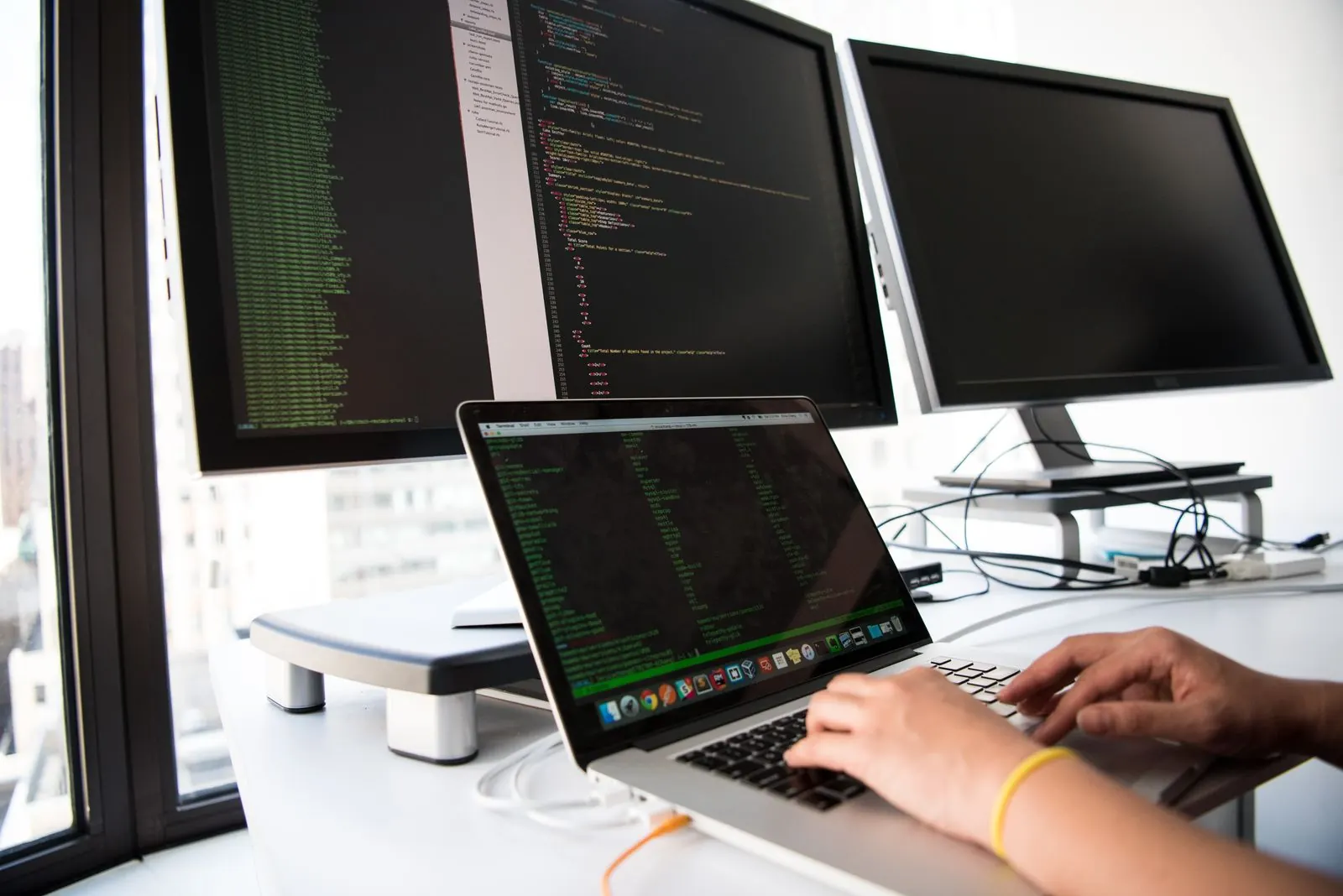 Developer working across several monitors